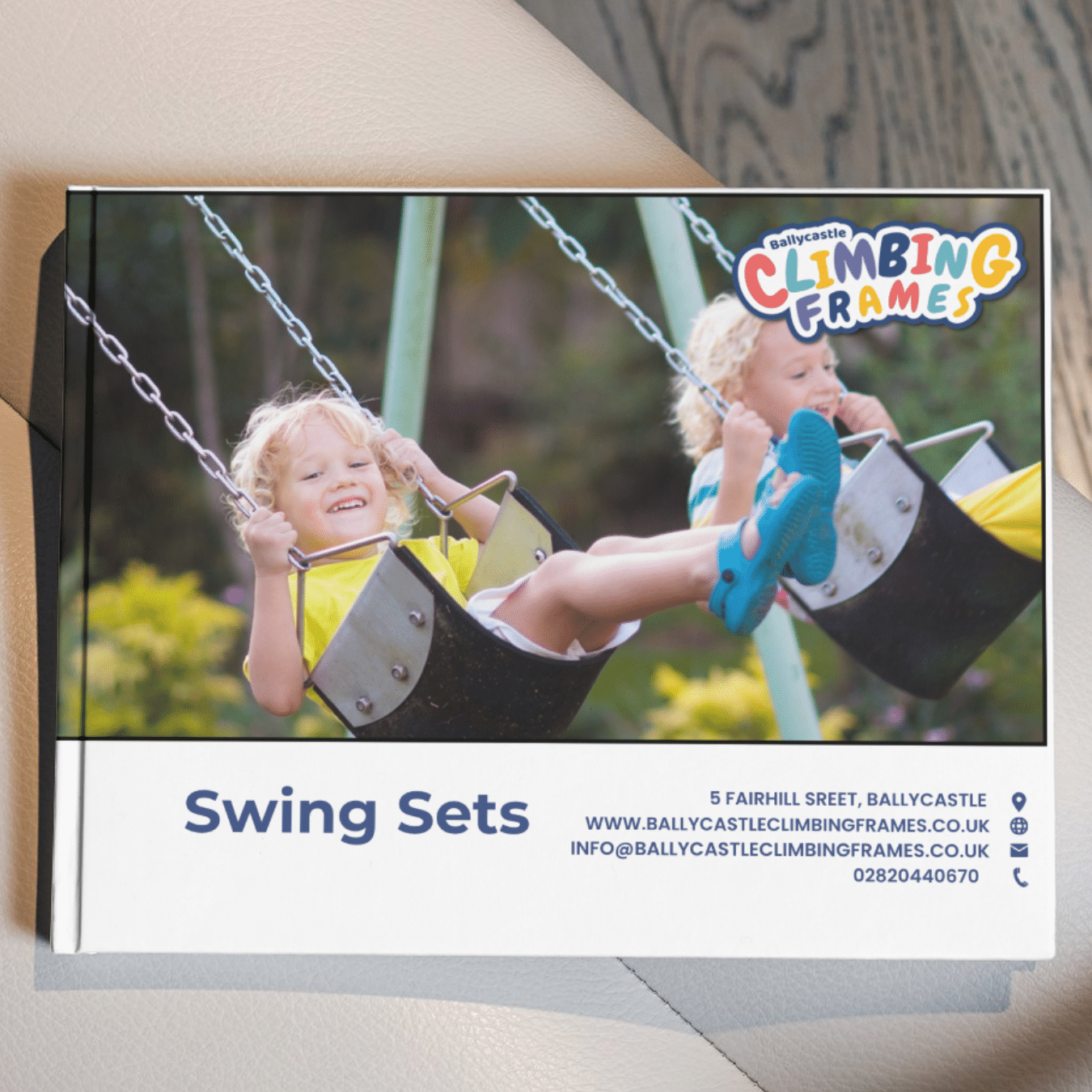 Two children on swings smiling joyfully, promoting Ballycastle Climbing Frames swing sets.