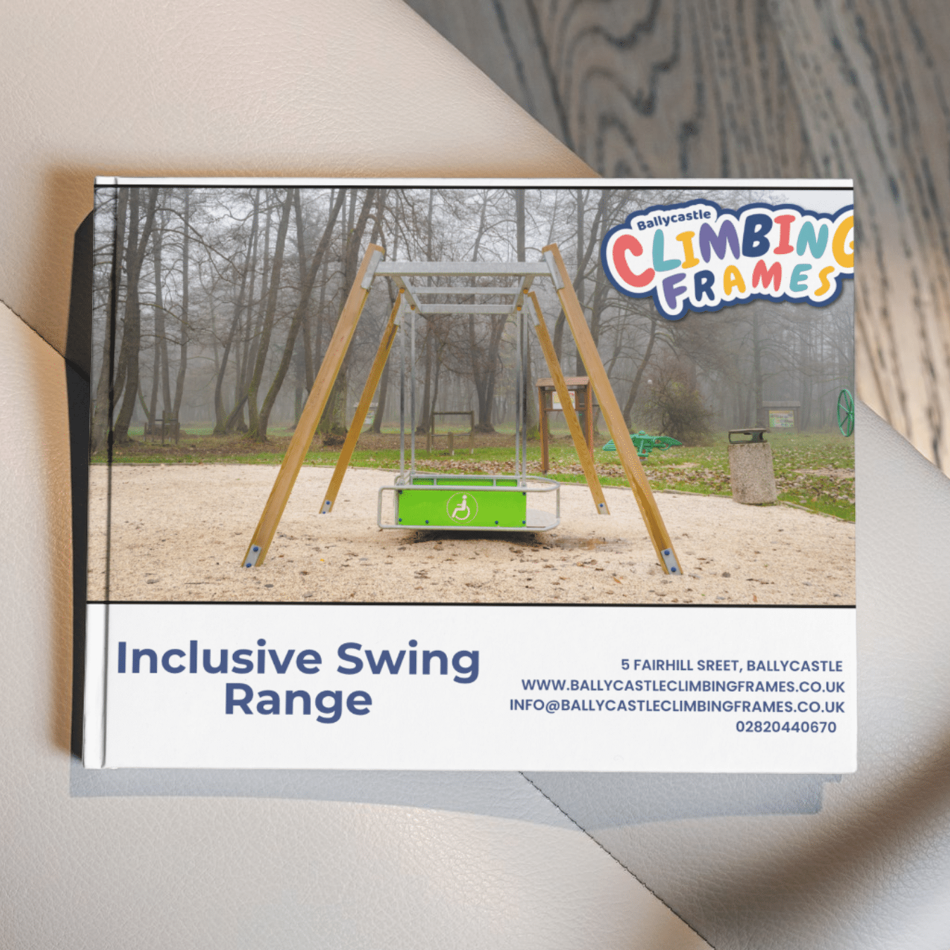 Inclusive swing in a park setting, with vendor details and logo "Ballycastle Climbing Frames" at the top.