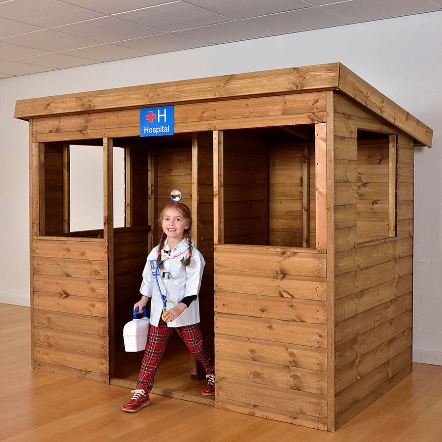 Child playing inside a wooden role-play playhouse used for educational and therapeutic environments.